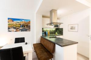- une cuisine avec des murs blancs et un comptoir dans l'établissement 101 Athen, Studio Apartment, 38m2 1-4 Pers, à Klagenfurt am Wörthersee