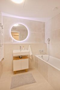 a bathroom with a sink and a tub and a mirror at Skau Sky Park Ivory by Zaha Hadid 11 Floor 4 Tower Free Parking in Nivy +18 photos