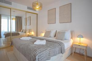a bedroom with a large bed with two mirrors at Skau Sky Park Ivory by Zaha Hadid 11 Floor 4 Tower Free Parking in Nivy