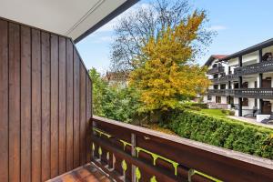 a balcony with a wooden fence and a tree at Ferienwohnung im Zentrum von Oberstaufen in Oberstaufen