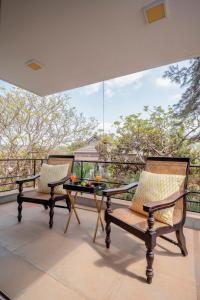 two chairs and a table on a balcony at Casa Mili 3 BHK Villa with Private Swimming Pool By Aquatica Stays in Assagao
