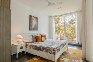 a bedroom with a bed and a large window at Casa Mili 3 BHK Villa with Private Swimming Pool By Aquatica Stays in Assagao +20 photos