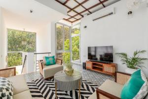 a living room with a couch and a tv at Casa Mili 3 BHK Villa with Private Swimming Pool By Aquatica Stays in Assagao