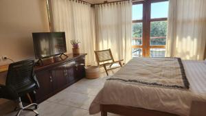 a bedroom with a bed and a flat screen tv at Teala Villa in Mantaak +25 photos