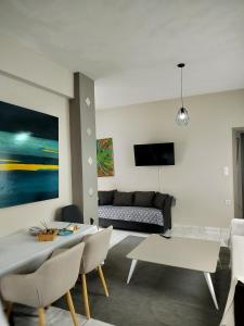 a living room with a couch and a table and chairs at Stylish Modern Flat in Pyrgos near Olympia in Pýrgos