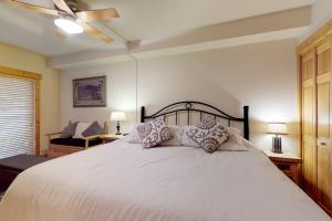 ein Schlafzimmer mit einem großen weißen Bett und Kissen in der Unterkunft Tenderfoot Lodge 2605 in Snake River Health Services Incorporated Heliport