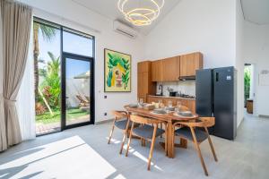 een keuken en eetkamer met een tafel en een koelkast bij Oasis Pandawa 1A - Just Built! Perfect Getaway Villa with Pool in Ungasan