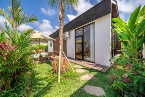 een huis met een palmboom in de tuin bij Oasis Pandawa 1A - Just Built! Perfect Getaway Villa with Pool in Ungasan