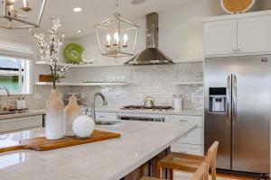 a kitchen with white cabinets and a stainless steel refrigerator at BytheSea Bluff Retreat Ocean Views & Coastal Trails in Seal Cove