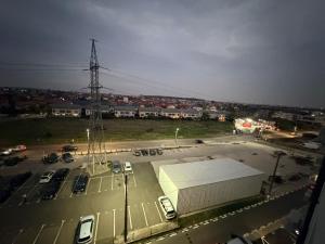 a parking lot with a large building and cars at JAD Militari Residence in Roşu