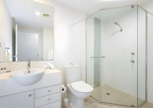 a bathroom with a toilet and a sink and a shower at Studio Lagoon Apartment in Salamander Bay +4 photos