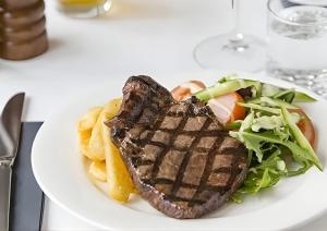 a plate of food with a steak and a salad at Studio Lagoon Apartment in Salamander Bay