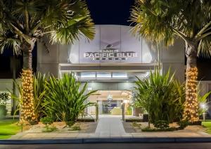 a building with palm trees in front of it at Studio Lagoon Apartment in Salamander Bay