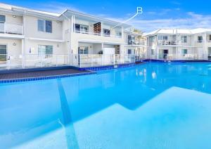 a large swimming pool in front of a building at Studio Lagoon Apartment in Salamander Bay +7 photos