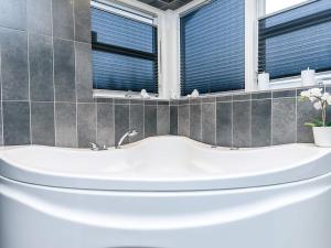 a white bath tub in a bathroom with windows at 10 person holiday home in Brovst-By Traum in Brovst