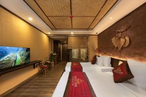 une chambre d'hôtel avec un lit et une télévision à écran plat dans l'établissement Tam Coc Oasis Resort & Spa, à Ninh Binh