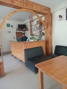 um homem sentado numa secretária com um portátil em Hotel Purnima by smugglers hotels em Kasol