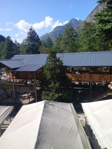 um grupo de tendas em frente a um edifício em Hotel Purnima by smugglers hotels em Kasol