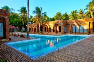 a swimming pool in front of a house at Pulojava Resort in Karimunjawa