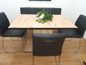 a wooden table with four chairs and a plant on it at Apartment Carmen in Brezje