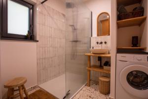 a bathroom with a shower and a washing machine at Racine lodges in Saint-Léon-sur-Vézère