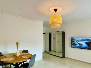 a dining room with a table and a chandelier at Caro Studio in Tunari +8 photos