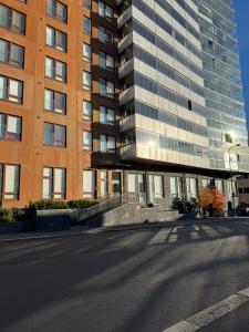 an empty street in front of a tall building at RD Apartments - Areenan Lumo in Tampere