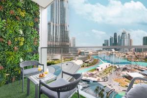 a balcony with chairs and a view of a city at The Grande Signature Experience Modern 2BR with Incredible Views of Burj Khalifa & Dubai Fountain, Steps Away from Dubai Mall in Dubai