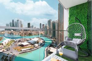 a balcony with a chair and a view of a city at The Grande Signature Experience Modern 2BR with Incredible Views of Burj Khalifa & Dubai Fountain, Steps Away from Dubai Mall in Dubai
