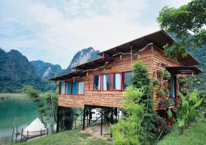 a wooden house on the side of a lake at Michi Camp Hữu Liên in Hữu Lũng