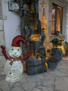 ティヴァトにあるApartmani Tamaraのクリスマスツリーの暖炉前雪だるま