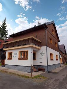 a large wooden building with windows on a street at Apartments Bayer - ex Apartments Pavel in Abertamy