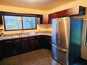 Una cocina con refrigerador de acero inoxidable y ventana. en Beautiful Entire House, en San Pedro