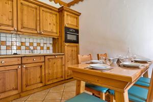 a kitchen with wooden cabinets and a wooden table at Mouflon, terrasse confort piscine, Spa in Champagny-en-Vanoise
