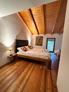 a bedroom with a large bed in a room with wooden floors at Maso Sasso - La Locanda di Putipù in Villa Lagarina