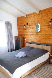 a bedroom with a bed in a wooden wall at Cabana EvAy in Ocnele Mari