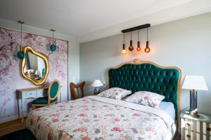 a bedroom with a bed with a green headboard and a mirror at Lovely House in Besançon