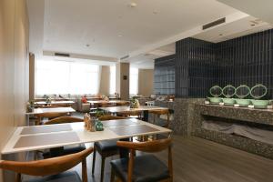 a restaurant with tables and chairs and a fireplace at Paco Hotel Tianhe Coach Terminal Metro Satation Guangzhou-Free Shuttle Bus for Canton Fair in Guangzhou