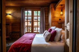a bedroom with a large bed in a wooden room at Hôtel Les Roches Fleuries in Cordon