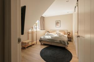 a bedroom with a bed and a black rug at Berken Villa | 24 personen in Wekerom