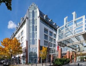 a tall white building with glass windows at Mercure Hotel Berlin Tempelhof in Berlin