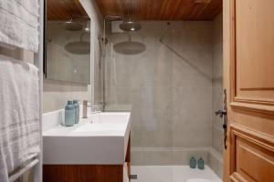 a bathroom with a white sink and a shower at Hôtel Les Roches Fleuries in Cordon +38 photos