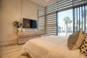 ein Schlafzimmer mit einem großen Bett und einem großen Fenster in der Unterkunft Luxury 3BR Villa with Maid Room & Private Beach Access in Ras al Khaimah