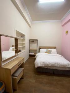 a bedroom with a bed and a desk and a mirror at 虎尾五八五民宿 in Huwei