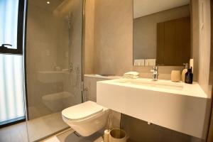 ein Badezimmer mit Toilette, Waschbecken und Dusche in der Unterkunft Luxury 3BR Villa with Maid Room & Private Beach Access in Ras al Khaimah