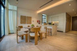 eine Küche und ein Esszimmer mit Tisch und Stühlen in der Unterkunft Luxury 3BR Villa with Maid Room & Private Beach Access in Ras al Khaimah