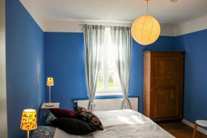 a blue bedroom with a bed and a window at Eisenbahnerhaus Klausdorf in Klausdorf Mecklenburg Vorpommern