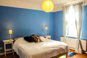 a blue bedroom with a bed and two lamps at Eisenbahnerhaus Klausdorf in Klausdorf Mecklenburg Vorpommern
