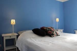 a blue room with a bed with two tables and two lamps at Eisenbahnerhaus Klausdorf in Klausdorf Mecklenburg Vorpommern