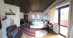 ein Schlafzimmer mit einem Bett und einem Balkon in der Unterkunft Къща за гости Начовата къща, Стойките, община Смолян in Vodata